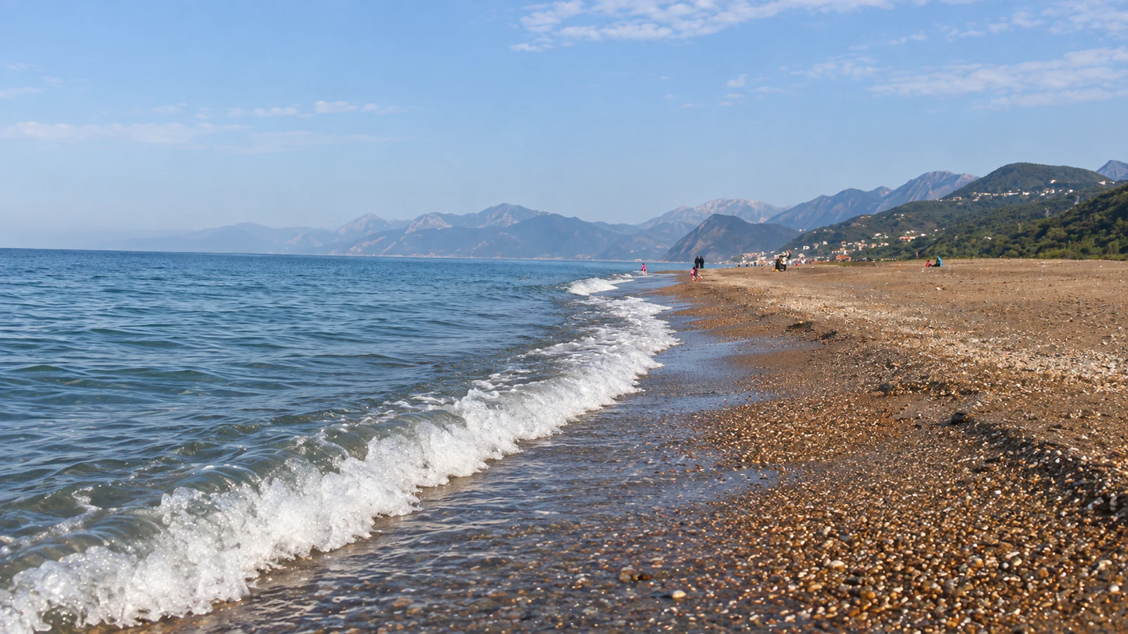 Vagues sur la plage de Tichy devant les montagnes du littoral de Béjaïa.