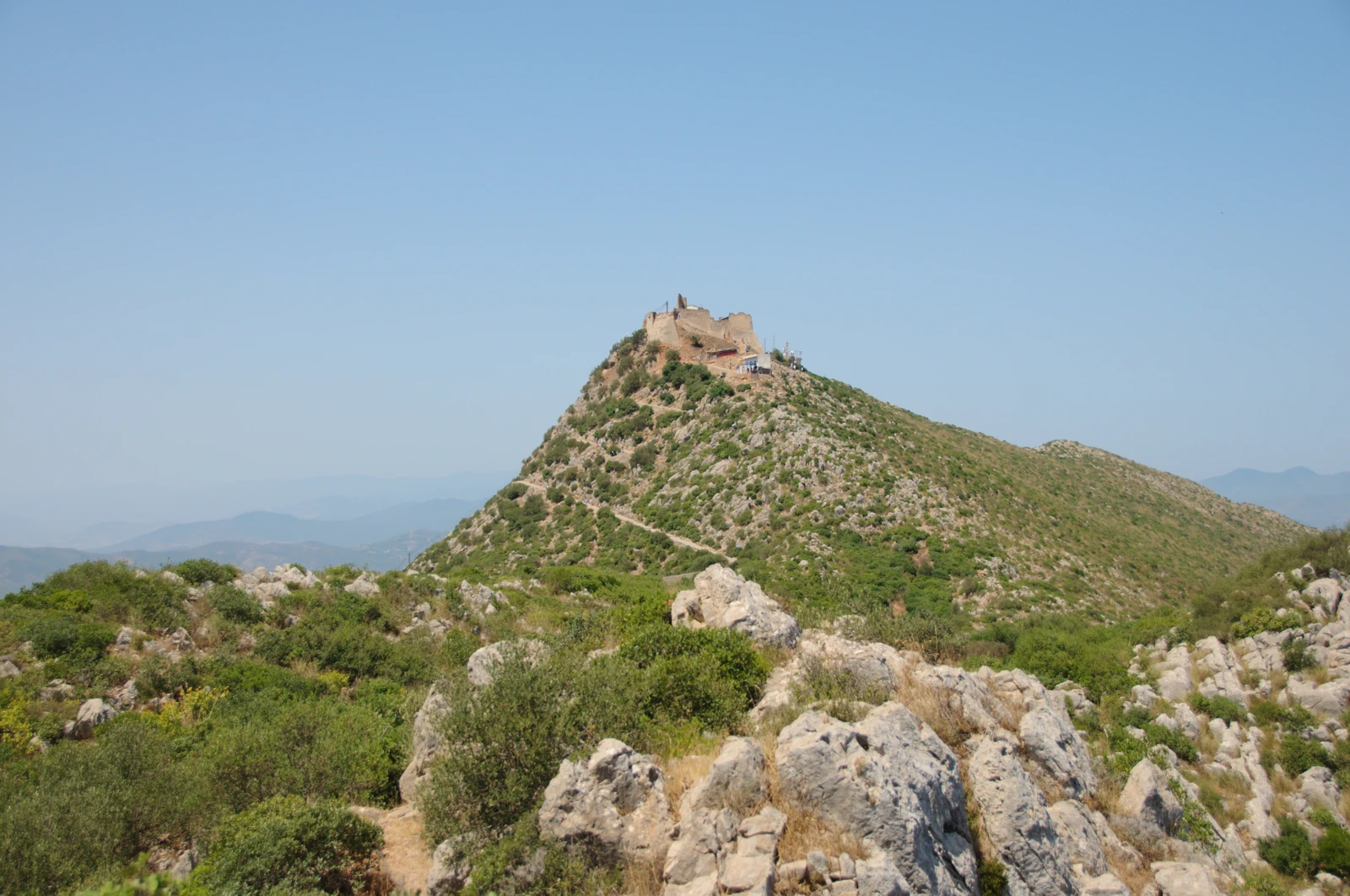 Fort de Yemma Gouraya au sommet rocheux, avec son chemin d’accès dans le maquis, près de Béjaïa.