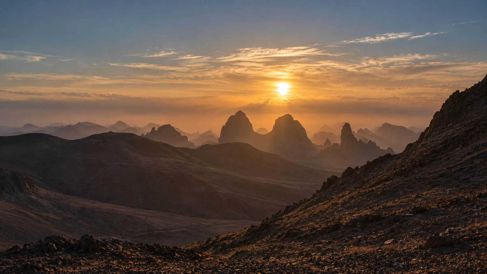 Illustration assistée par IA : Vue du lever du soleil sur les reliefs volcaniques de l’Atakor depuis l’Assekrem.