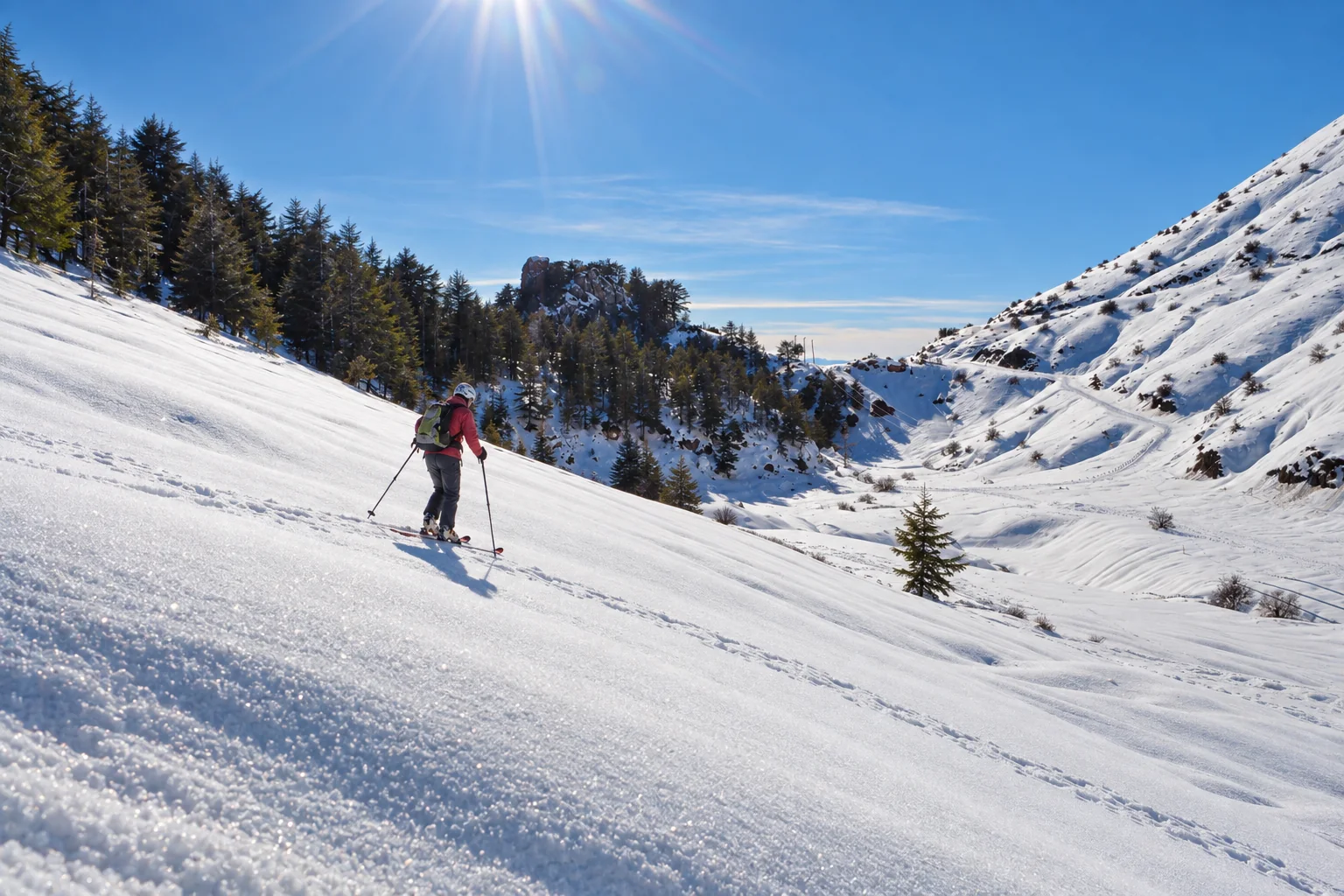 Scène de ski de randonnée sur une combe enneigée de Tikjda, avec skieur.