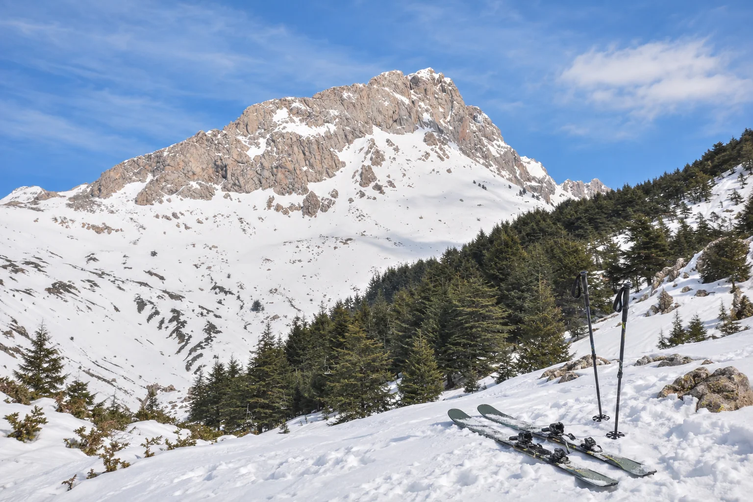 Skis de randonnée sur une vue enneigée du massif de Tikjda.
