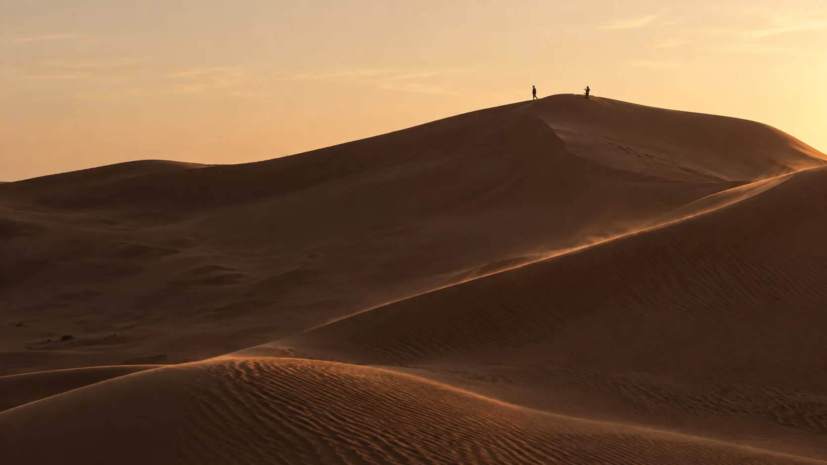 Illustration assistée par IA : Deux voyageurs minuscules sur une crête de dunes du Grand Erg près de Timimoun, à la lumière du soir.