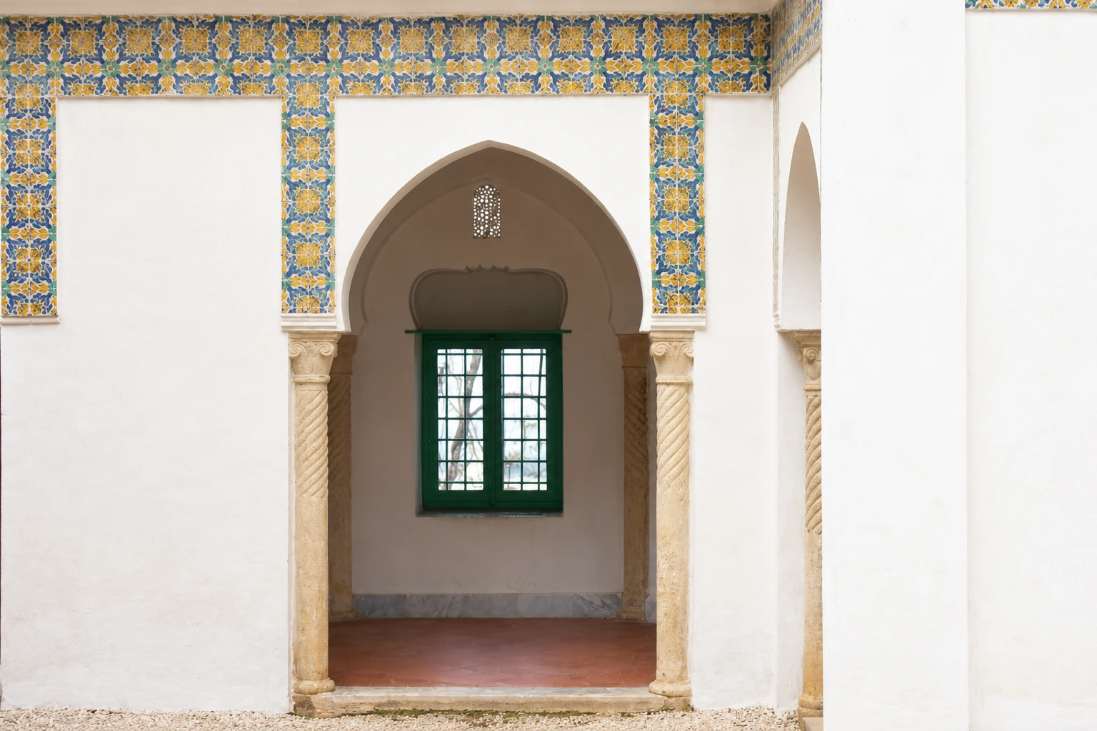 Une porte à arc de la villa Abd-el-Tif, ses colonnes et sa fenêtre verte.