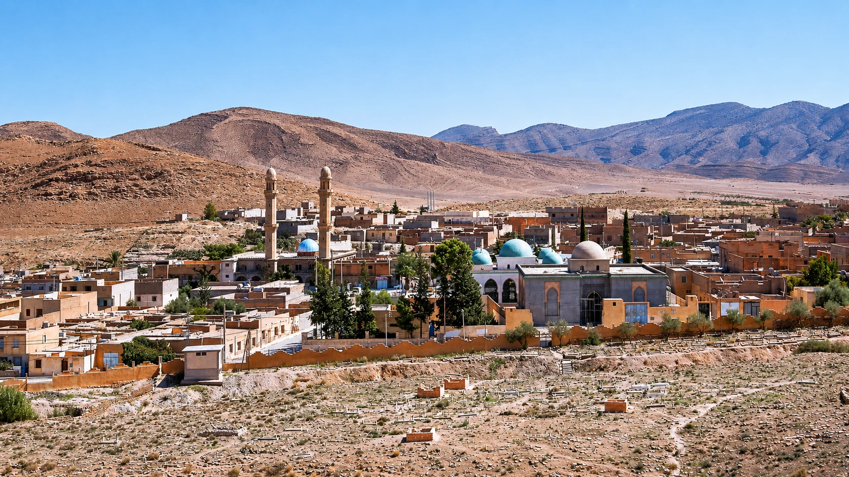 Maisons, dômes et minarets d’El Hamel devant les reliefs rocheux.