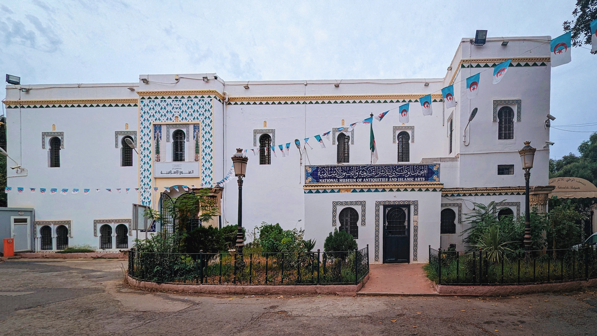 Façade blanche ornée de faïences et jardin du musée national des Antiquités et des Arts islamiques à Alger.