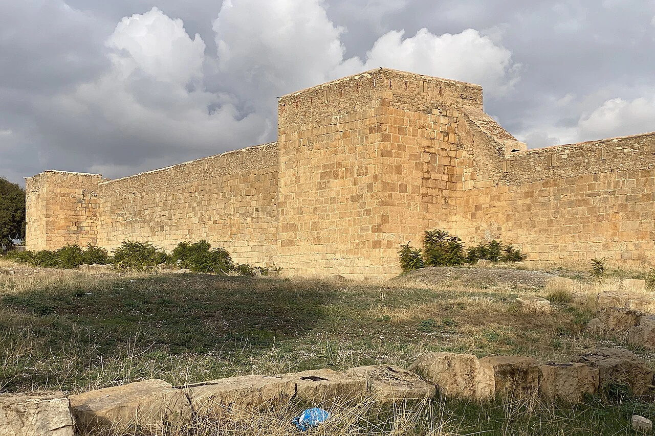 Photographie réelle des remparts de la forteresse byzantine de Sétif, vestiges de Sitifis, avec tours et blocs de pierre conservés dans le tissu urbain.