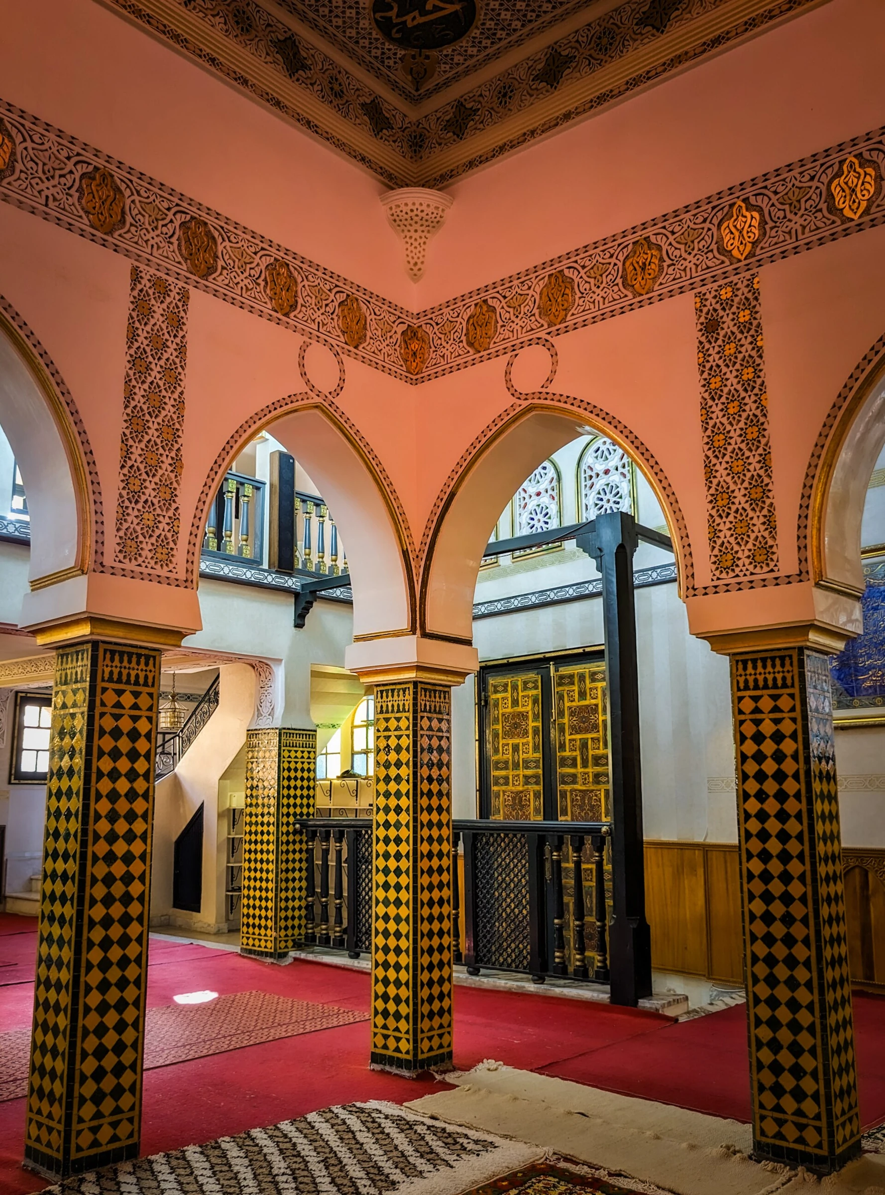 Intérieur de la mosquée de la zaouïa Alawiyya de Mostaganem photographié en août 2023. Arcs et motifs de faïences conservés sans redessin.