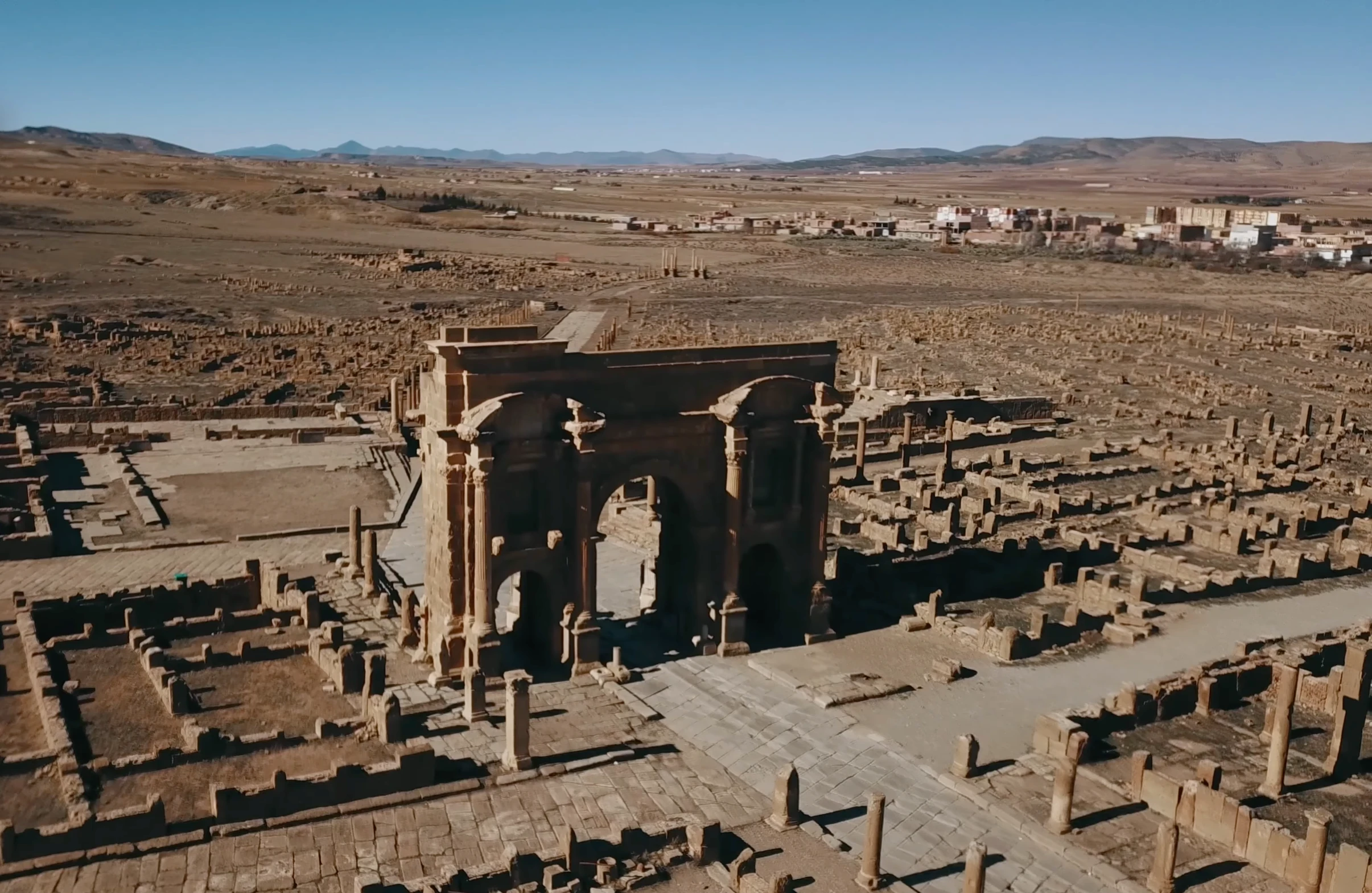 Vue de l’arc de Trajan et des rues du site antique de Timgad