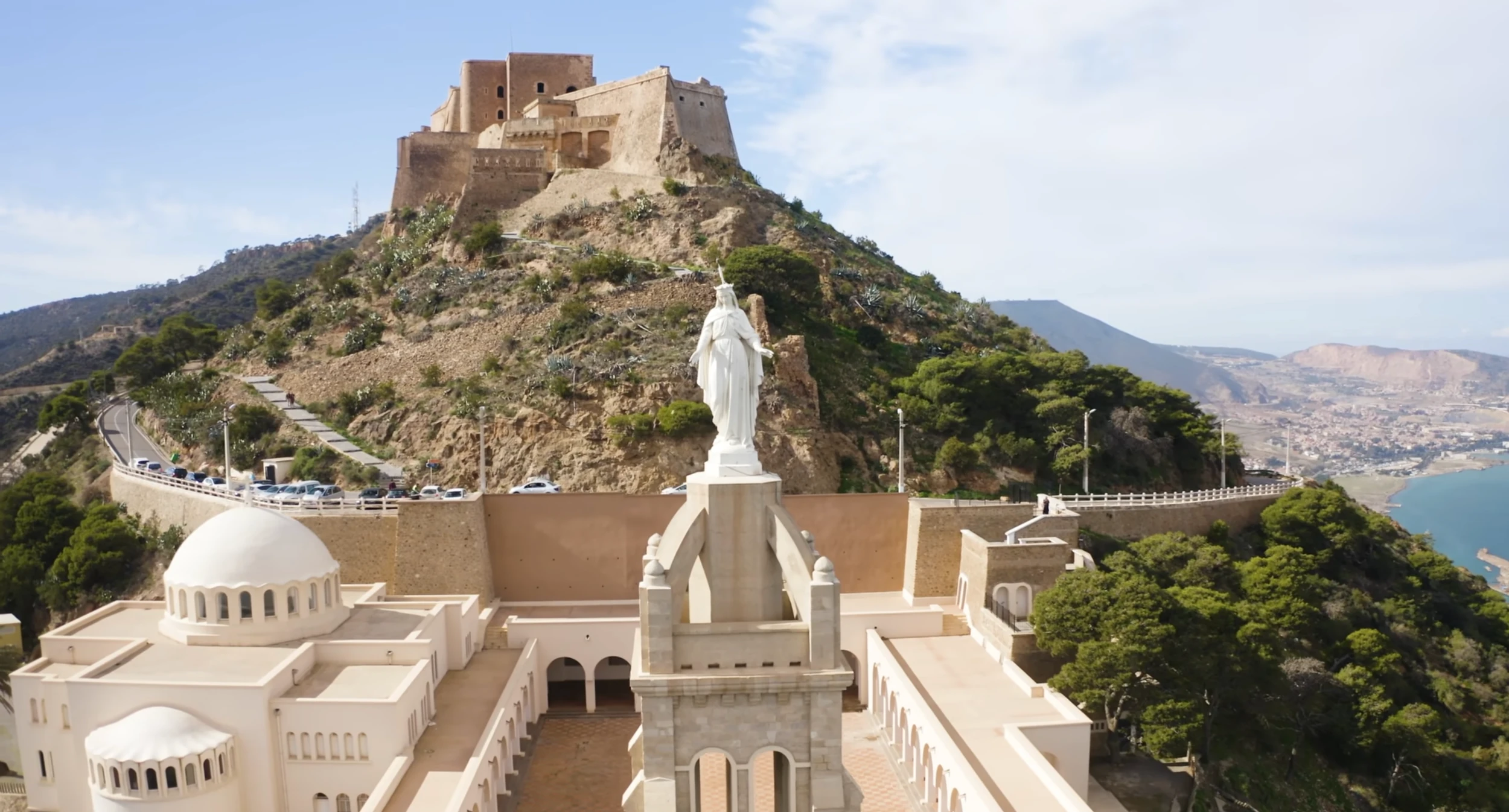 La chapelle de Santa Cruz et sa statue de la Vierge, au pied du fort de Santa Cruz qui domine Oran depuis le Murdjadjo, la baie en contrebas.